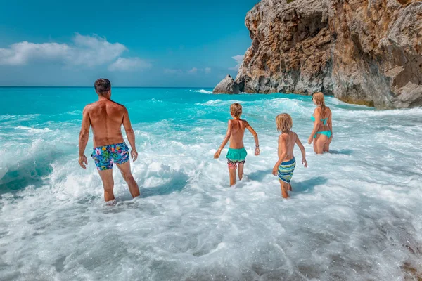 暑い夏の休暇中にビーチの海岸に海の波で楽しい休暇に若い家族 — ストック写真