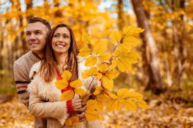 Genç çift güneşli sonbahar ormanda zevk gülümseyen