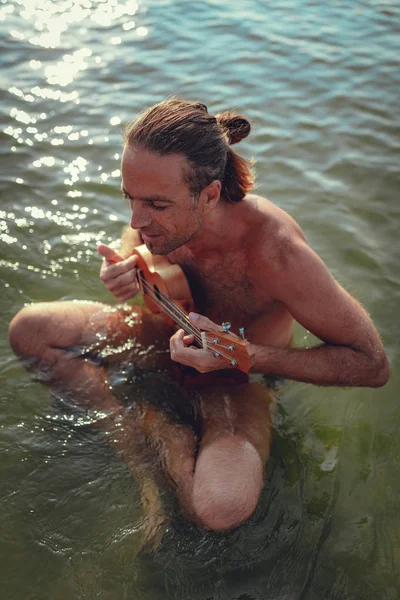 Adult Musician Sitting Water Playing Ukulele Sunset — Stock Photo, Image