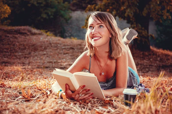 Smiling Young Woman Lying Fall Leaves Reading Book Park — Stock Photo, Image