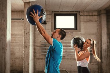 Genç kadının koç ile spor salonunda zor egzersiz yapması