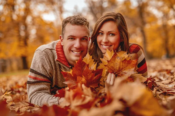 Sorrindo Casal Deitado Chão Coberto Folhas Desfrutando — Fotografia de Stock