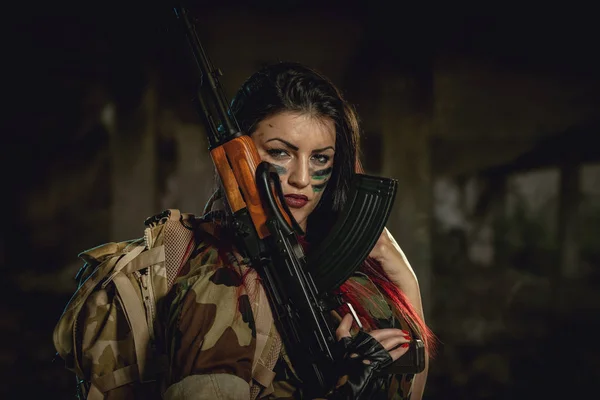 迷彩シャツの肩にもたれて機関銃を保持の暗い髪の女性 — ストック写真