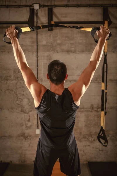 Young muscular man training in gym