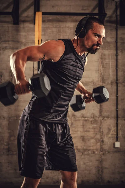 Young muscular man training in gym