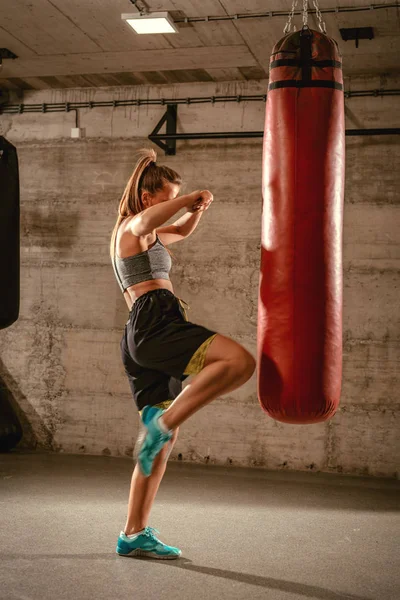 Жінка ударяє боксерську сумку — стокове фото