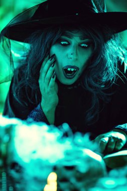 Çok ürpertici dumanlı yeşillikler örümcek ağı tam yüzüne cadıyla sihirli içecek tarifi okuyor. Cadılar Bayramı kavramı.