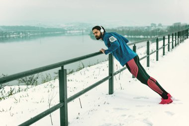 Genç adam atlet itme yapıyor nehir yanında kış eğitimi sırasında ups 