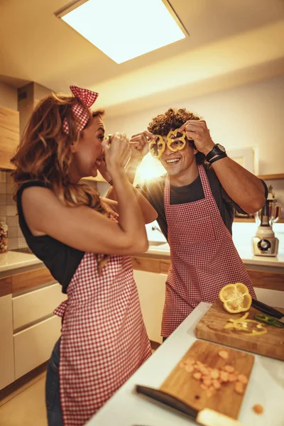 家庭の台所で一緒に健康的な食事を作るの楽しみを持っている幸せな若いカップル — ストック写真