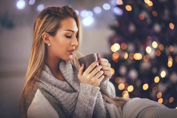 Unga Leende Kvinna Dricka Kopp Kaffe Glödande Jul Inredda Interiören — Stockfoto