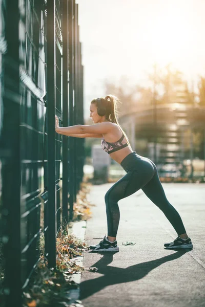 Young Runner Headphones Doing Stretching Exercise Metal Fence — Stock Photo, Image