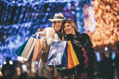 Genç kadınlarla renkli alışveriş torbaları City gece Noel zamanı, sokak yürüyüş