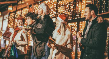 Eğleniyor ve tutan genç neşeli arkadaşlarım Noel açık partisinde sunar 