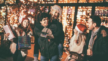 Eğleniyor ve tutan genç neşeli arkadaşlarım Noel açık partisinde sunar 