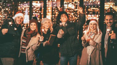Havai fişekleri ile Noel akşam eğlenmek neşeli genç arkadaşlar