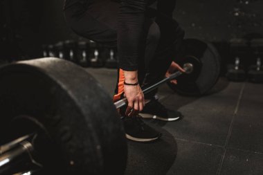 Yakın çekim kas el ile halter salonunda egzersiz yapmaya hazır