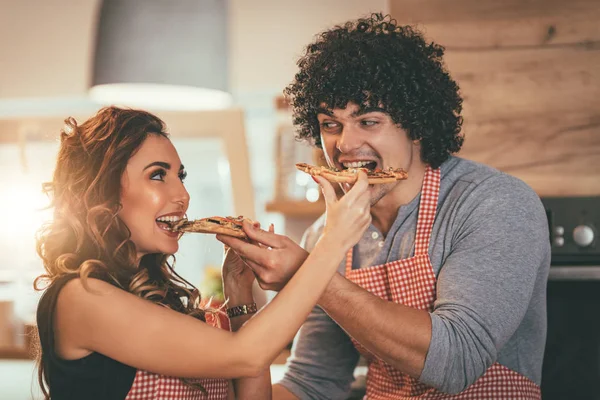 若い男と女がピザの部分でお互いを給餌 — ストック写真
