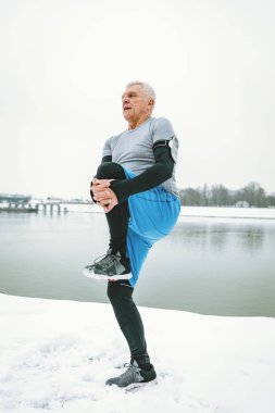 Nehir kenarında kış eğitim sırasında germe sportif komuta sizde