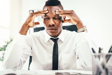 Ofiste oturan endişeli Afrika işadamı