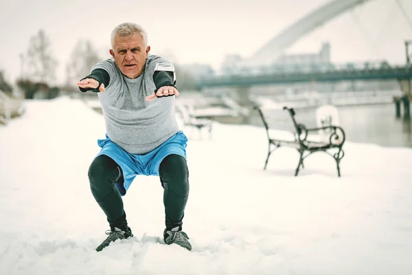 Hombre Mayor Activo Haciendo Sentadillas Por Río Durante Entrenamiento Invierno —  Fotos de Stock