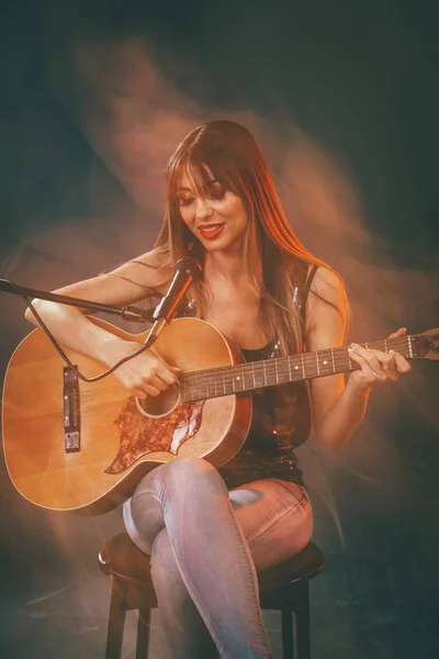 Joven Sonriente Mujer Sentada Tocando Guitarra —  Fotos de Stock