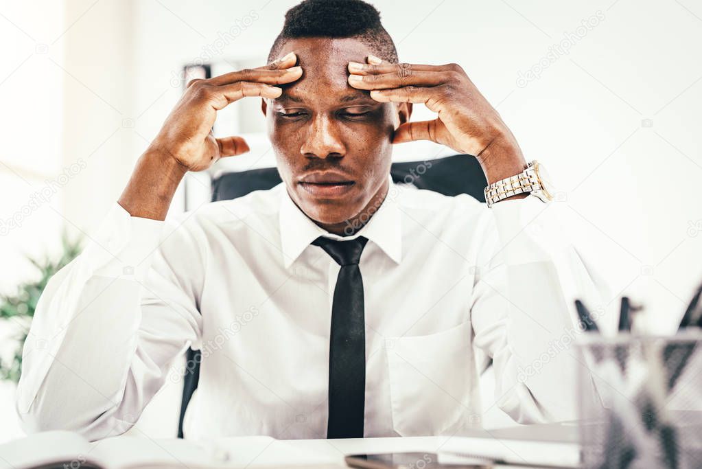 Anxious African businessman sitting in office