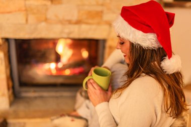 genç gülümseyen kadın evde şöminenin yanında çay içme