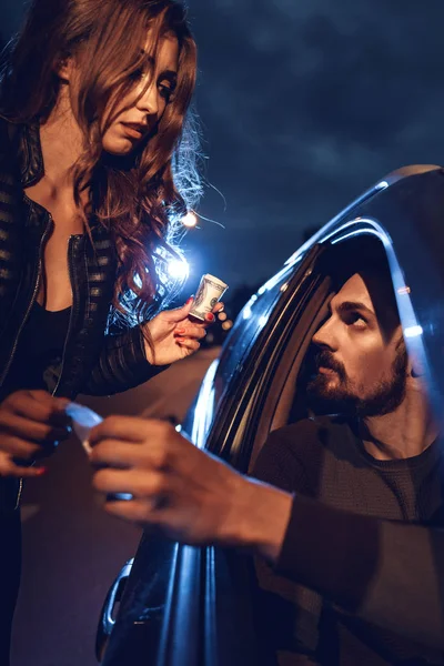 ディーラー車から若い女性に薬物の小さな袋を販売の表示を閉じる — ストック写真