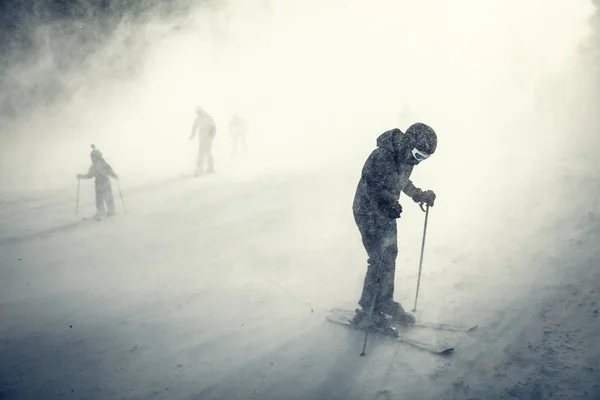 Young man riding snowboard and enjoying frozen winter day on mountain slopes