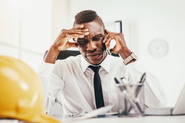 Smartphone üzerinde konuşmak ve modern ofis içinde laptop üzerinde Afrika işadamı