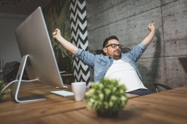 Genç yakışıklı office germe ve çalışma saatleri sonu bekleyen oturan işadamı overworked. 