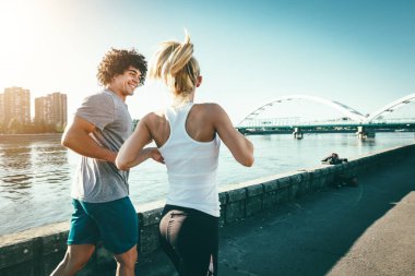 Genç çift dışında nehir kenarında güneş doğarken koşu