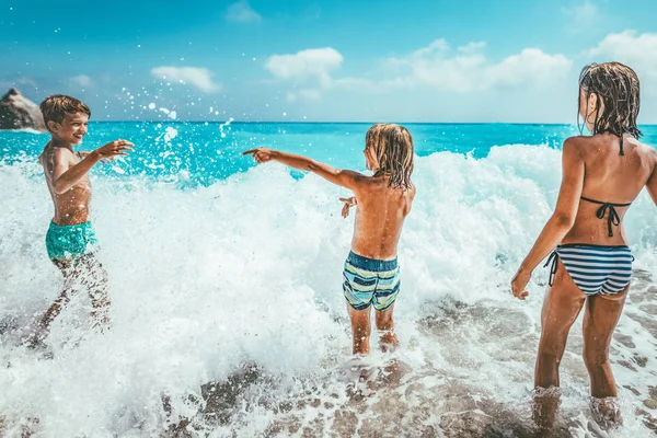 兄弟と姉妹は 暑い夏の休暇中にビーチの海岸で遊ぶ — ストック写真