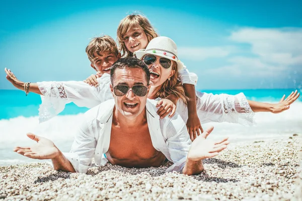 砂浜のビーチで楽しんで小さな子供を持つ若い家族 — ストック写真