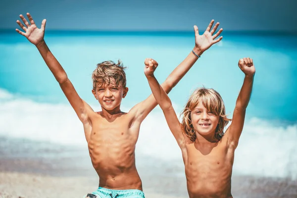 Dva Roztomilý Bratři Vztaženými Pažemi Sedí Pláži Usmíval Při Pohledu — Stock fotografie