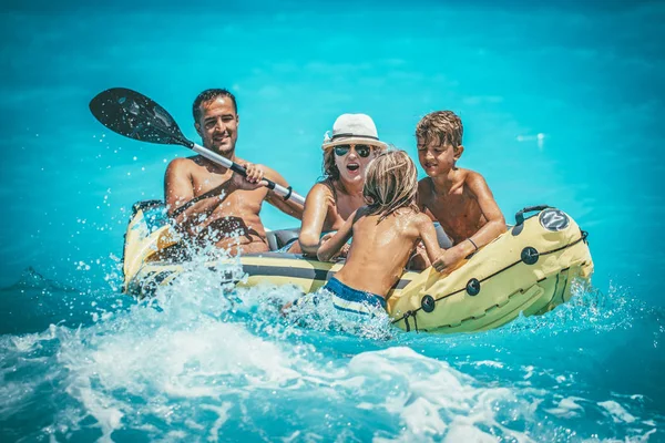 快乐家庭享受在热带海洋水中的黄色皮划艇划船 — 图库照片