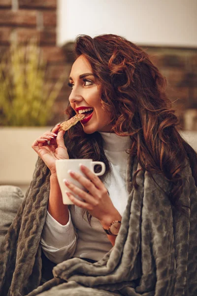 Young Woman Sitting Sofa Tucked Soft Blanket Drinking Coffee Cookie — Stock Photo, Image