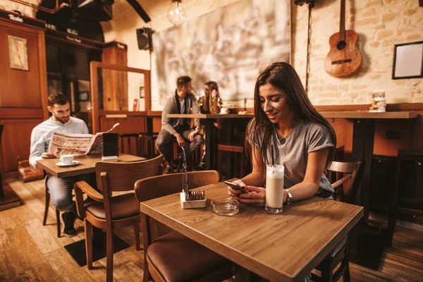 Mladá Žena Textových Zpráv Pro Smartphone Pití Kávy Kavárně — Stock fotografie