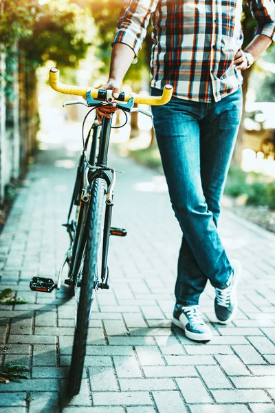 自転車の側に立って若い男性の足の表示を閉じる — ストック写真