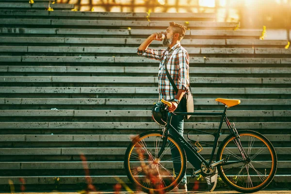 コーヒーを飲むと 自転車の横に立っている中年のスタイリッシュな男性 — ストック写真