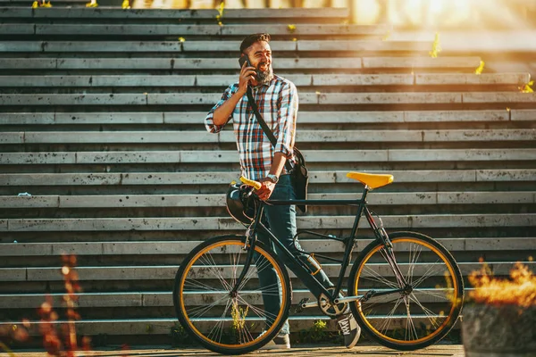 自転車の横にあるウォーキングとスマート フォンで話すひげ中年の男性 — ストック写真