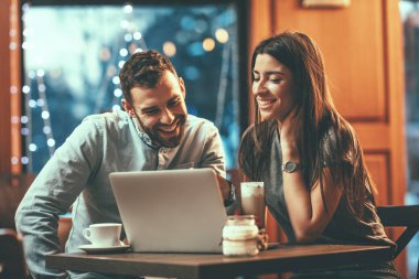 Kahve içme ve kafede dizüstü bilgisayar üzerinde çalışan Modern iş adamları