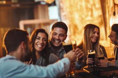 Bira içmek, konuşmak ve having fun kafede arkadaşlar genç grup