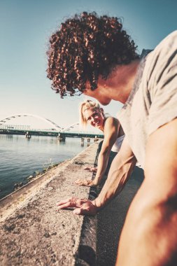 Genç çift gülümseyen eğitim açık havada sırasında açık şınav mutlu eğitim tarafından Nehri.