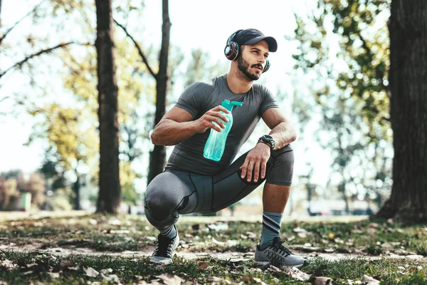 Joven Con Auriculares Bebiendo Agua Descansando Después Entrenar Parque Otoño —  Fotos de Stock