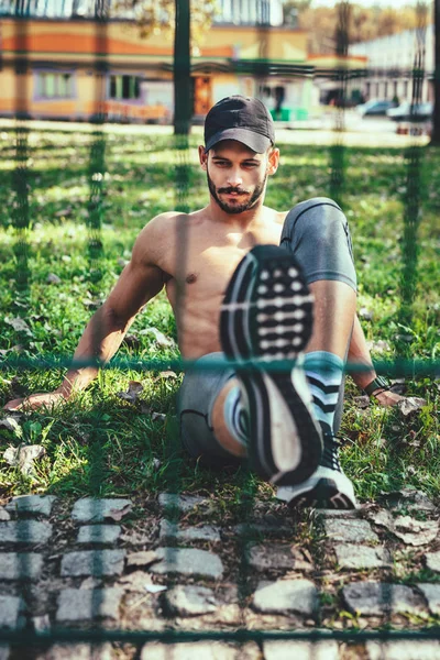 Jeune Homme Avec Casque Faisant Exercice Assis Dans Parc — Photo