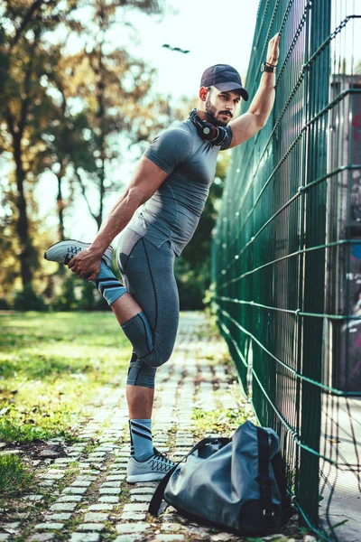 Hombre Joven Auriculares Haciendo Ejercicio Estiramiento Parque Verde —  Fotos de Stock