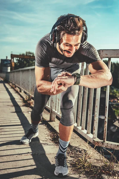 Joven Deportista Con Auriculares Iniciar Cronómetro Antes Entrenar Puente —  Fotos de Stock