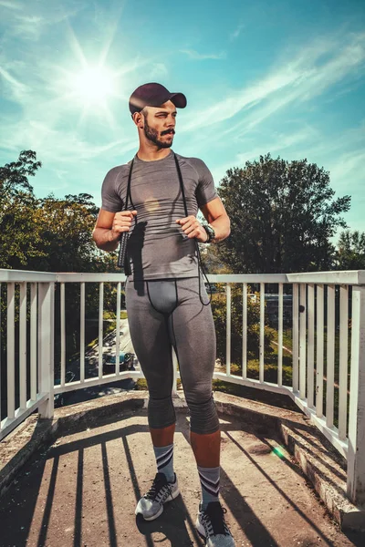 Joven Deportista Urbano Sosteniendo Cuerda Descansando Después Entrenar Parque —  Fotos de Stock