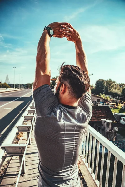 Молодой Человек Делает Упражнения Растяжку Металлическом Мосту — стоковое фото